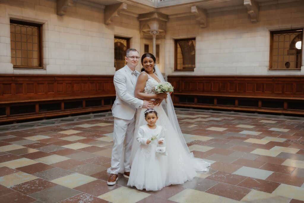 Heiraten in Dänemark: Hochzeitspaar mit Blumenmädchen in einem historischen Saal.