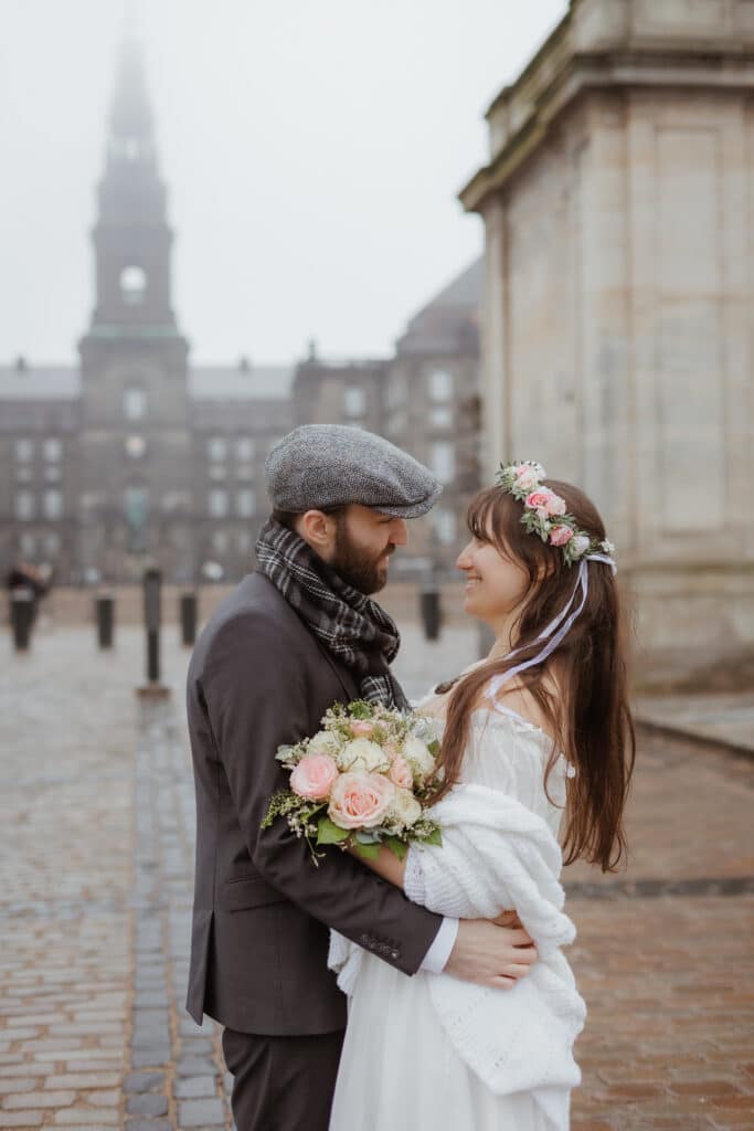 Heiraten in Dänemark: Brautpaar vor dem Christiansborg Schloss in Kopenhagen an einem romantischen Wintertag.